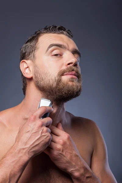 Cheerful bearded guy is caring of his appearance — Stockfoto