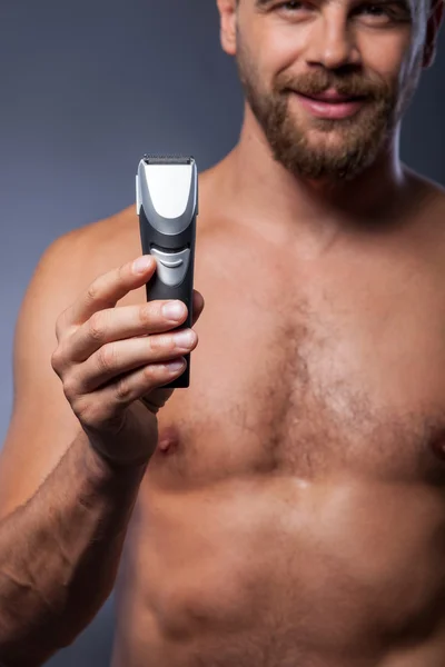Jovem atraente está apresentando novo barbeador — Fotografia de Stock