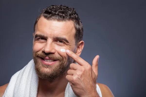 Handsome guy with beard is treating skin — Stock Fotó