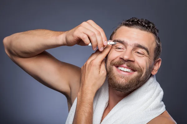 Attractive bearded guy is caring of his appearance — Stockfoto