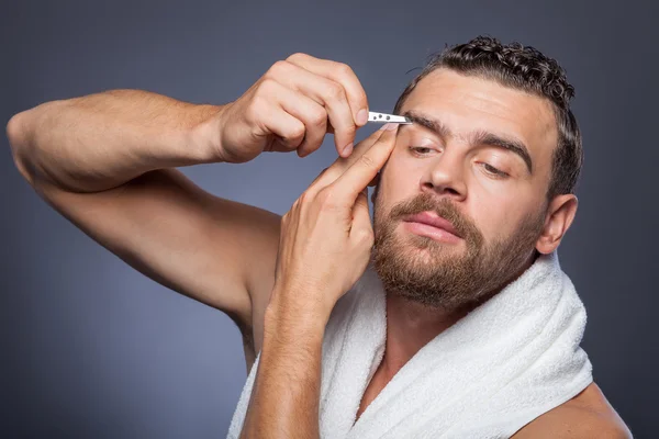 Fröhlicher junger Mann achtet auf sein Äußeres — Stockfoto