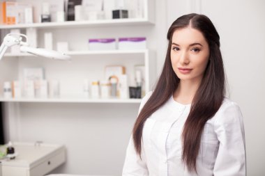 Attractive female expert beautician is waiting for customer