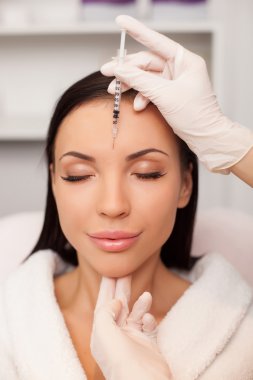 Cheerful young lady is visiting her cosmetologist