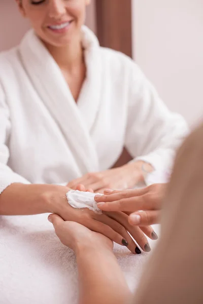 Cheerful girl is caring of her skin at beauty salon — Stockfoto