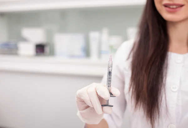 Pretty female cosmetician is preparing syringe for procedure — Stok fotoğraf