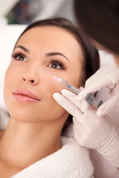 Professional young cosmetician is serving her patient — Stock Photo, Image