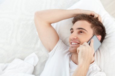 Çekici bir genç adam iletişim için telefon kullanıyor