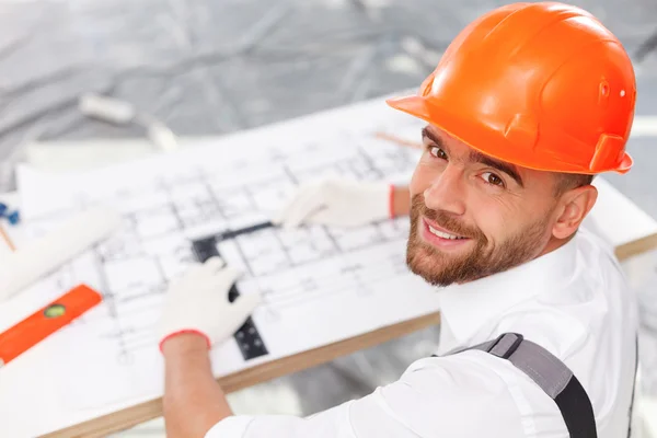 Alegre construtor masculino está trabalhando em nova construção — Fotografia de Stock