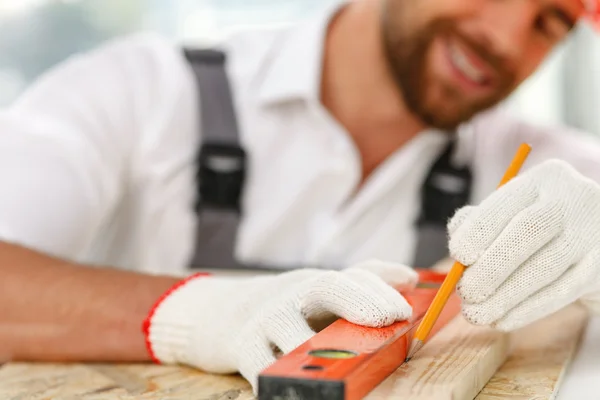 Atractivo carpintero masculino está tomando medidas de material —  Fotos de Stock