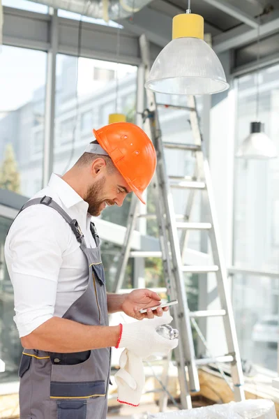 Ingeniero atractivo está utilizando el teléfono para la comunicación — Foto de Stock