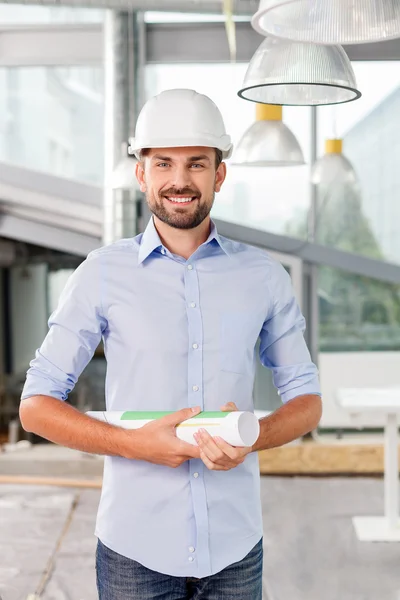 Cheerful young builder is presenting his project — Zdjęcie stockowe