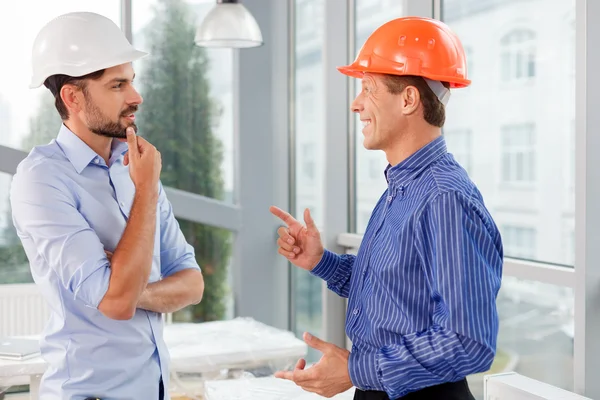 Alegre dos ingenieros están discutiendo el edificio —  Fotos de Stock