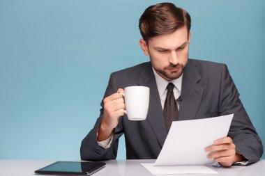 Attractive male newscaster with cup of tea