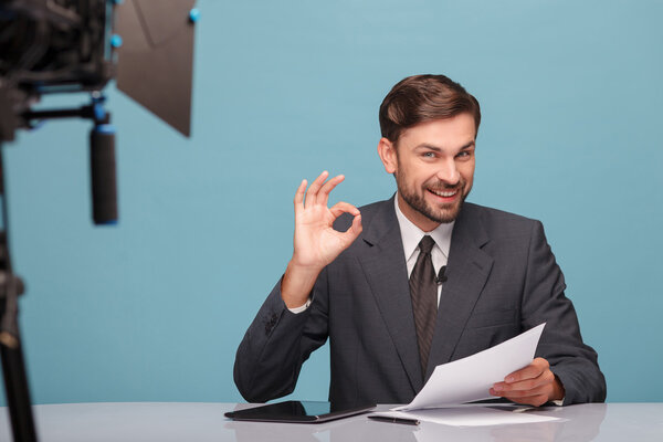 Attractive young tv newscaster is gesturing positively