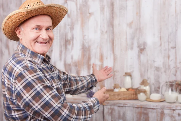 Un fermier âgé joyeux présente son travail — Photo