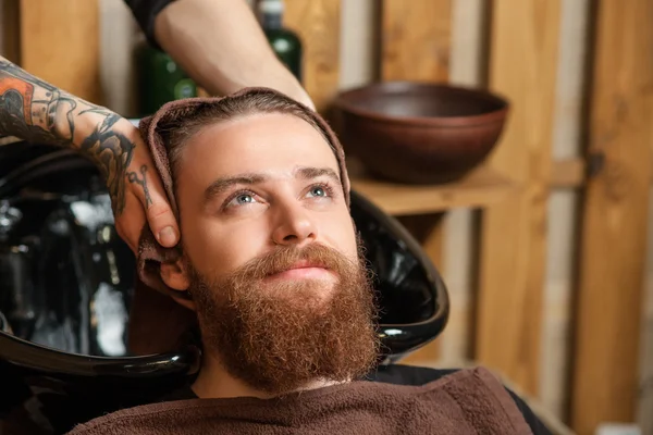 Cheerful guy with beard at beauty salon
