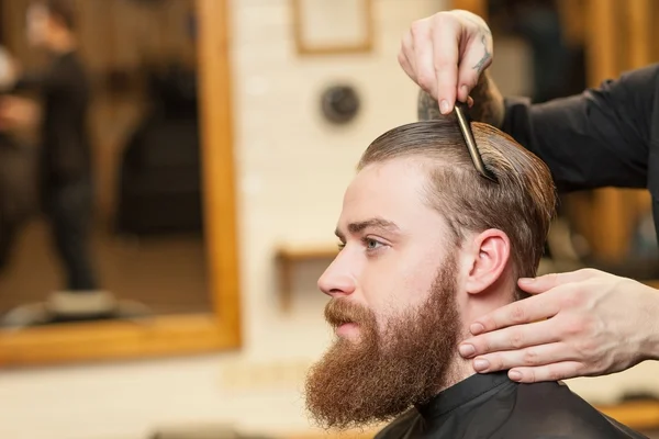 Веселий чоловічий перукар обслуговує свого клієнта — стокове фото