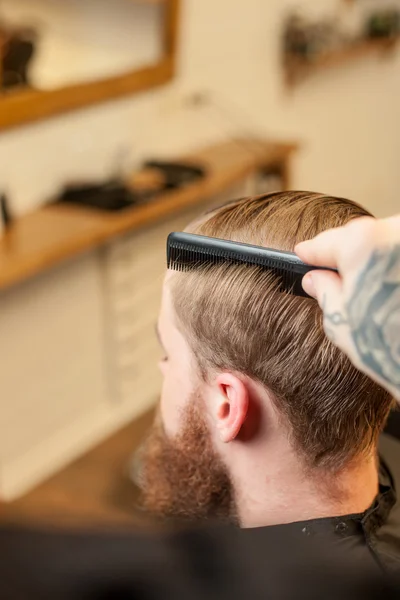 Professional male hairdresser is working with comb — Stock Fotó