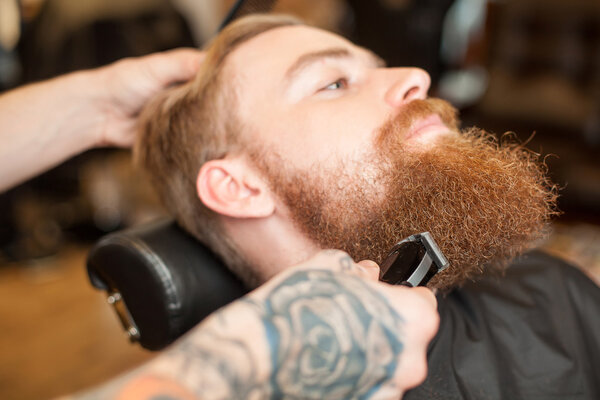 Cheerful young man is attending beauty shop