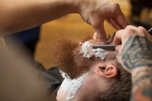 Geschickter männlicher Friseur dient seinem Kunden — Stockfoto