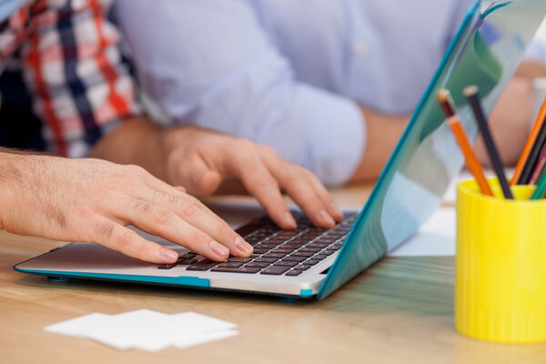 Опытный творческий коллектив работает с ноутбуком
