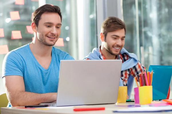 Skillful two male workers are using notebook — 图库照片