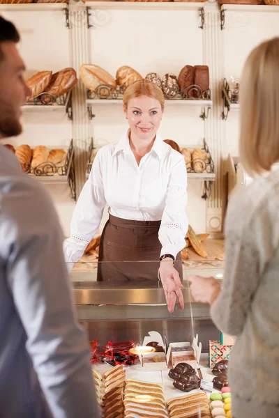Beautiful saleswoman is selling bakery products — Stock Photo, Image
