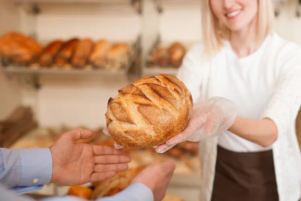 Skillful female baker is selling fresh pastry — 图库照片