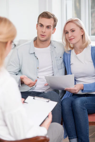 Cheerful husband and wife are asking advice in therapist — Stockfoto