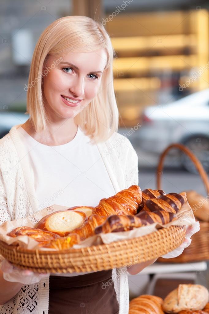 Beautiful young saleswoman is working in bakery