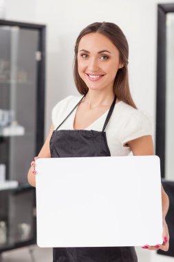 Beautiful female hairstylist is presenting a billboard