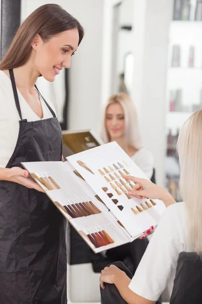 Pretty young hairdresser is serving her customer — Stock fotografie