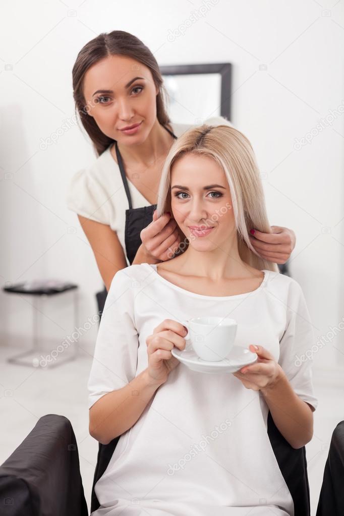 Pretty female hairstylist is working at beauty salon
