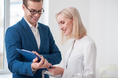 Cheerful young realtor is working with client