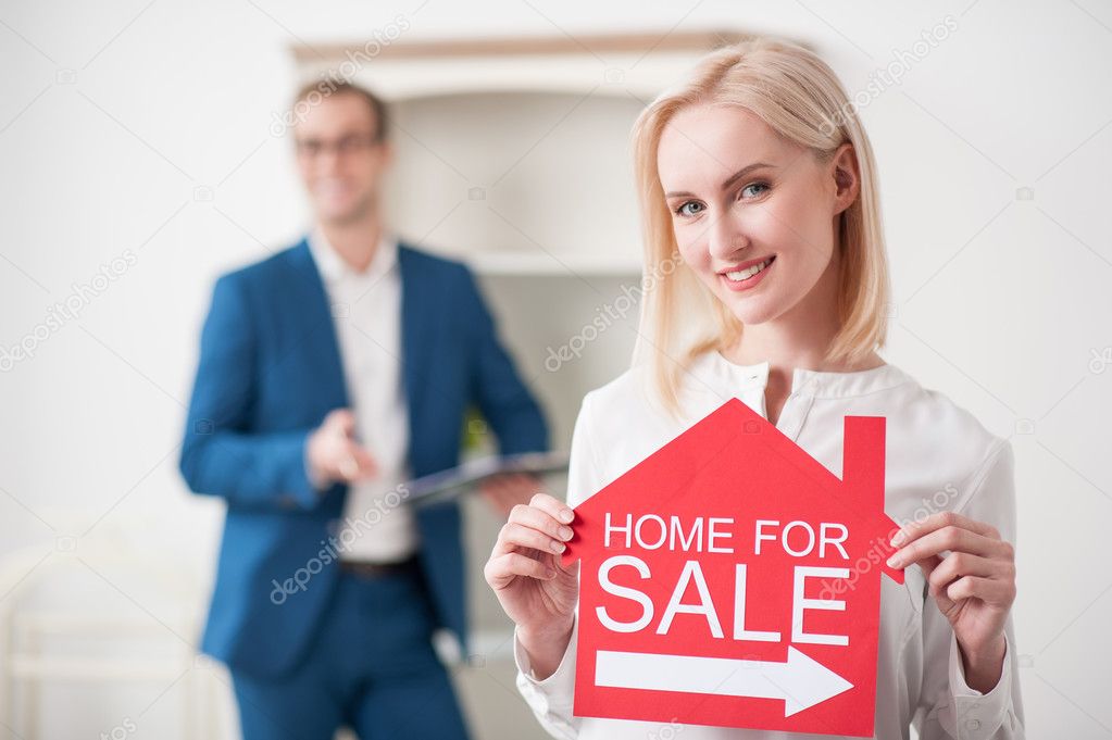 Cheerful young woman is presenting her house