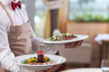 Skillful male cafe worker is serving customers