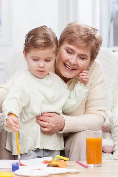 Cute small girl is painting with her grandparent — Stock Photo, Image