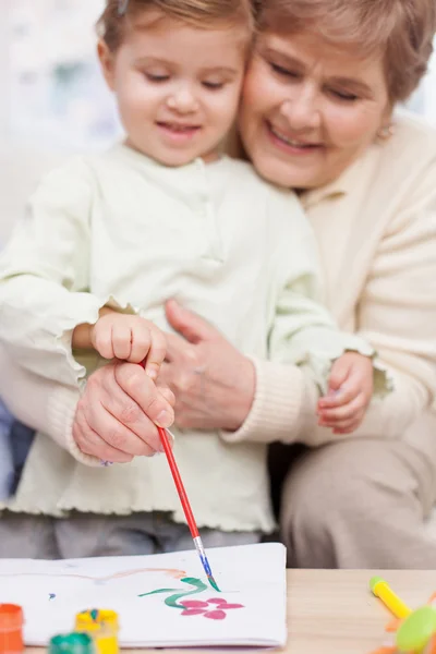 Hübsche Großeltern bringen Kind das Malen bei — Stockfoto