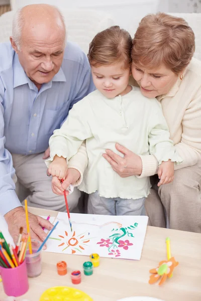 Cute family is painting together at home — Stok fotoğraf