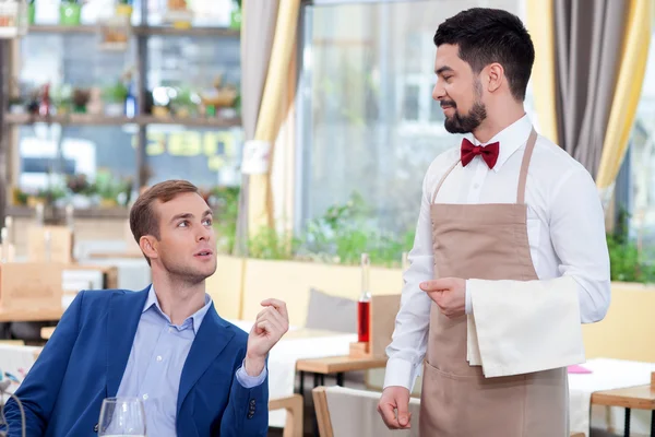 Alegre trabajador café masculino está sirviendo a un cliente —  Fotos de Stock