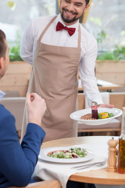 Attractive young waiter is working at restaurant — Stockfoto