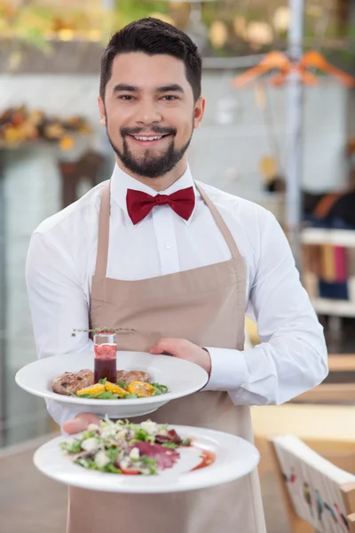 Guapo joven camarero está trabajando en el restaurante — Foto de Stock