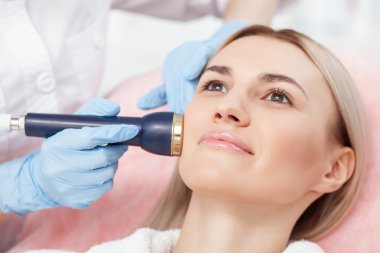 Skillful female cosmetologist is serving a customer