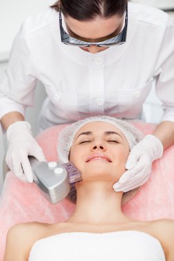 Cheerful female beautician is working with patient