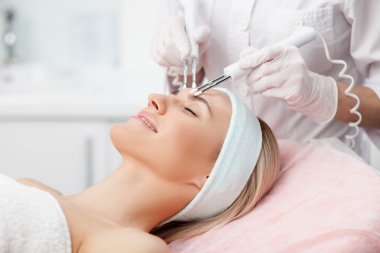 Cheerful female therapist is curing human skin