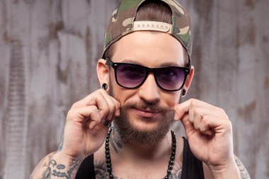 Cheerful young man with beard and tattoo