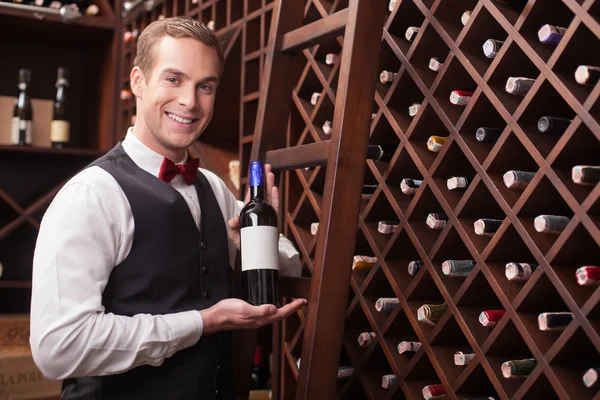 Attractive young sommelier is showing elegant drink — Stockfoto