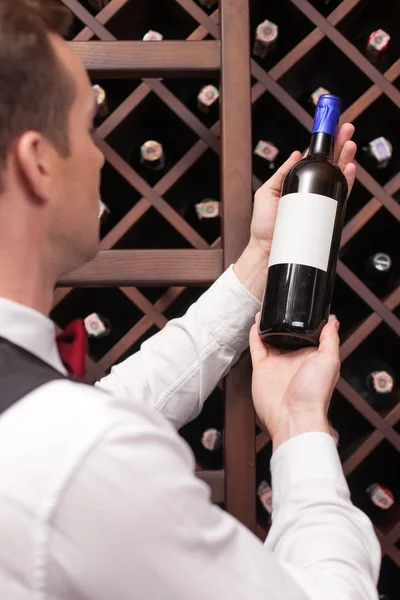 Attractive young sommelier is choosing perfect drink — ストック写真