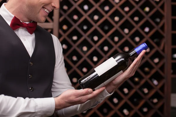 Cute male waiter is choosing perfect drink — Stockfoto