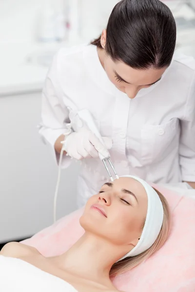 Professional young therapist is curing female skin — Stok fotoğraf